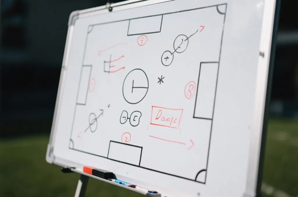 A close-up of a soccer tactical whiteboard with diagrams and strategy, editorial style